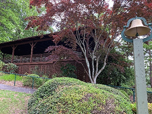 Bulloch Chapel on hill with shrubbery and Japanese maple tree in front