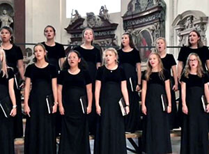 Girls in black dresses, standing, singing