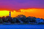 Dramatic sky - purple, pink, orange with lighthouse in the background