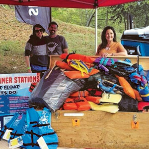 3 LLA members show donated life jackets stacked on table