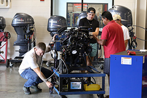 Students working on MerCruiser outboard in the lab
