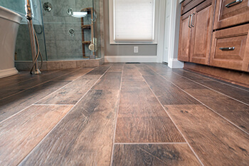 Wood flooring from low vantage point looking toward a door with cabinets to the side