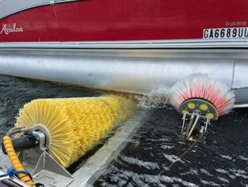 A drivei-n boat wash - view of yellow scrubbers on hull of motorboat in the water