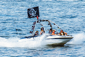 Speed boat on Lake Lanier flying pirate flag with passengers sitting in front 