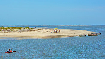 Hunting Island beach with boaters, kayakers, and sunbathers