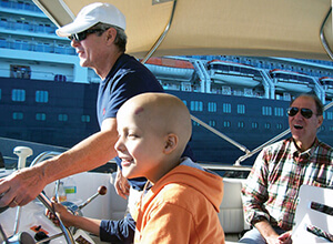 Boat driver and child enjoying the ride at a previous Freedom Waters Foundation event.