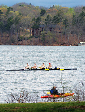 4 people rowing in one skull, and one kayak on Lake Lanier