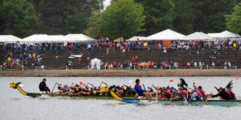 Dragon boat racing on Lake Lanier with spectators watching from shore.