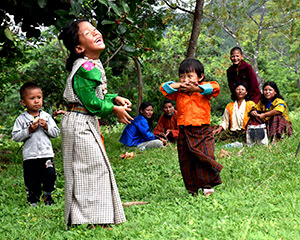 A Bhutanese family playing in the grass.