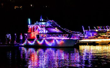 Large boats near docks with colorful Christmas lights.