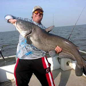 Fisherman holding his very large catfish catch.