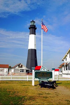 View of Tybee Lighthouse with American flag in background.