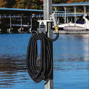 DockBloxx new hose holder that is attached to a metal pole on a marina dock.