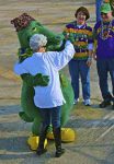 A woman dancing with a gator-costumed character to Zydeco music.