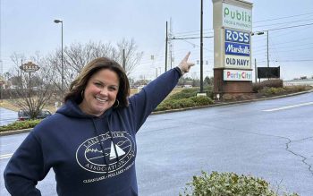 Amy McGuire, standing outside the Publix shopping center points to their new location.