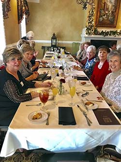Buford Lanier Womans Club members sit on either side of a long table at a restaurant.