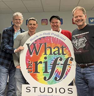 The four podcast members holding the "What the riff" logo sign.