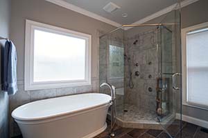 A bathroom remodel showing freej-standing tub, glass shower and large picture window.