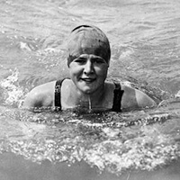 Head shot of Gertrude Ederle swimming with swim cap on.