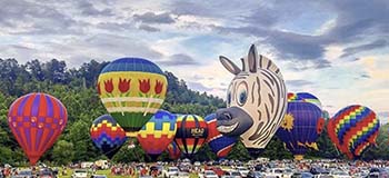Wide view of colorful hot air balloons on the ground in Helen, GA