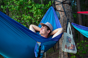 Young man relaxing in a blue hammock.