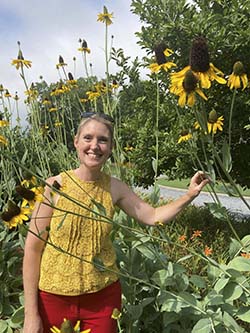WSB garden show host Ashley Frasca standing in a garden of sunflowers.