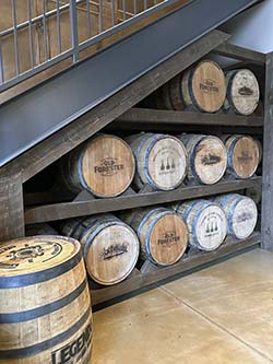 Bourbon barrels stacked under a stairway. 