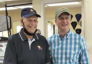 Head and shoulders photo of Tom, with black golf shirt and cap on left, and Brent in light blue and white plaid shirt on right. 