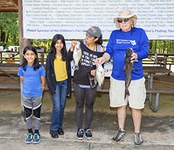 A young family with their fishing captain, showing off the fish they caught.