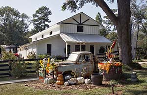 The front of the Nutwood Winery - a white, barn structure with an old truck and pumpkins in the foreground.