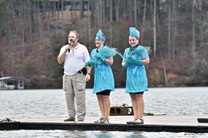 2023 Polar Bear plunge photo of two girls dressed in blue, getting ready to jump off the dock into Lake Lanier. 