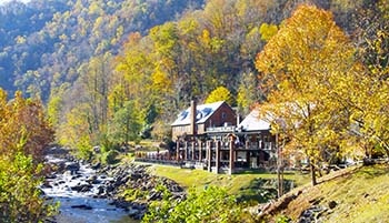 Outdoor scene with fall colors, the Cheoah River and Tapoco Lodge.