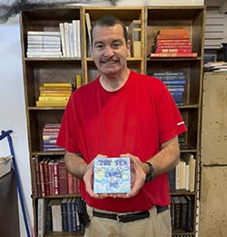 A downtown Gainesville bookstore employee shows the small artwork he found on one Free Art Friday.