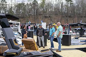 A small group of men standing on a boat dock at the Lake Lanier Boat Show, looking at boats. 