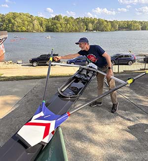 A view of a rower setting up his rowing shell for spectators to view.