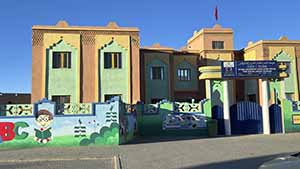 A Moroccan school with bright colors of red, green and blue on the front.